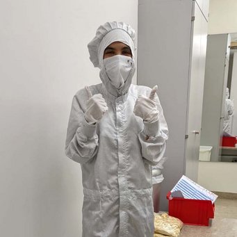 Get dressed for the lab! Undergraduate Research Opportunities participant Irene Pellini in a clean room dress shows thumbs up