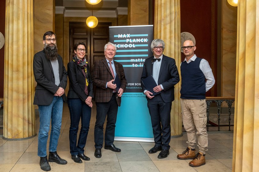From left to right: Prof. Stefan Klumpp, Prof. Sarah Köster, both MtL Fellows from the Faculty of Physics at University of Göttingen, Prof. Bernhard Eitel, Rector of Heidelberg University, Prof. Metin Tolan, President of Göttingen University, and Prof. Joachim Spatz, Speaker of the Max Planck School Matter to Life. Die fünf in der Bildbeschreibung erwähnten Personen stehen gemeinsam vor einem Rollup, das das Logo der Max Planck School Matter to Life zeigt.