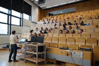 A lecture hall half filled with students during a lecture