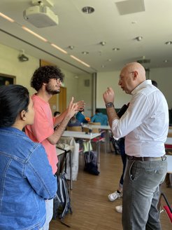 Prof. Stefan Hell is pictured in a conversation with two students