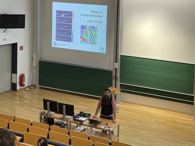 Prof. Stefan Klumpp is pictured standing in front at the lecture hall and presenting