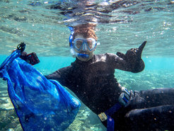 Philipp Baur snorkeling in a cool pose, holding a bag to collect his samples