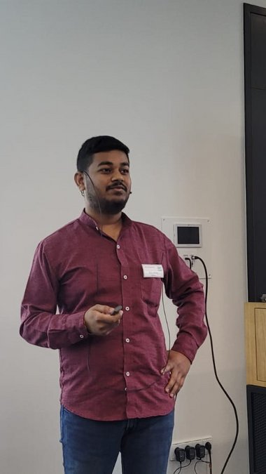 Nitin Bohra props his left hand at his side after his presentation and looks into the audience, the laser pointer still slightly raised in his right hand.
