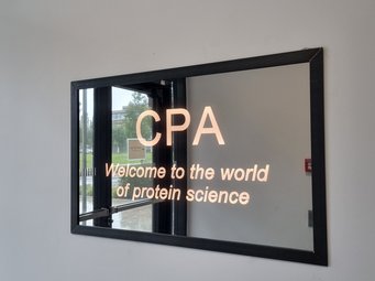 Our hosts for this event, a center dedicated to protein research A mirror with the inscription "CPA - Welcome to the world of protein science" greets visitors to the building in the entrance area.