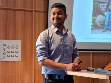 An MtL student stands at the lectern during the Q & A session after his lecture and looks to his left with a smile.