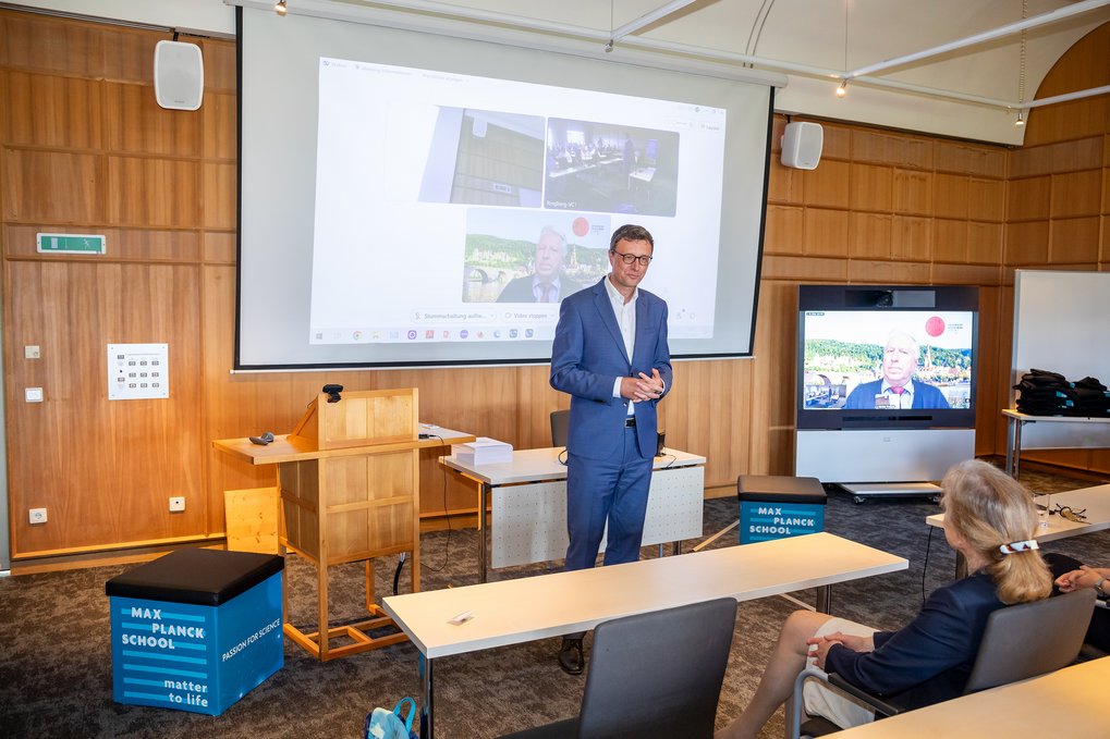 Patrick Cramer, President of the MPG, gives a short speech. The room is bathed in wooden colors.