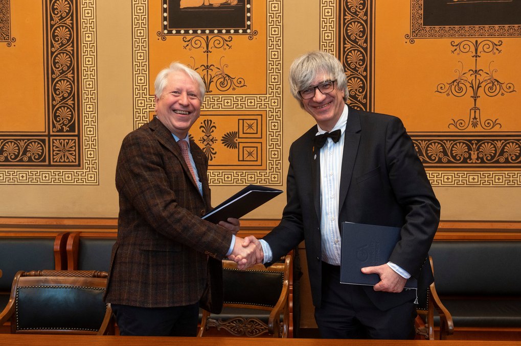Prof. Dr. Metin Tolan and Prof. Dr. Bernhard Eitel shake hands after signing the Matter to Life joint degree contract