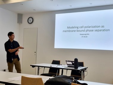 Matter to Life URO student Kueyoung Kim giving a scientific presentation and pointing at his presentation with a laser pointer