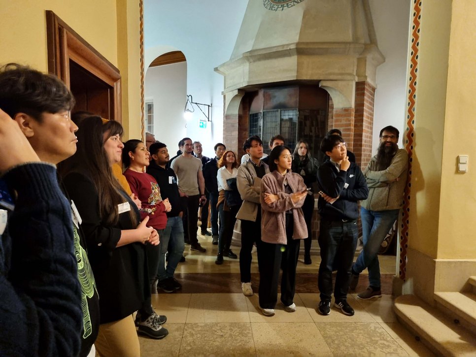 During the castle tour, the participants stand in the high hallway of the castle and listen intently