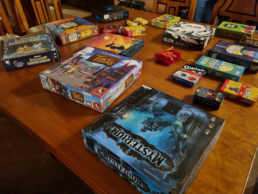 A selection of board games lies on a wooden table