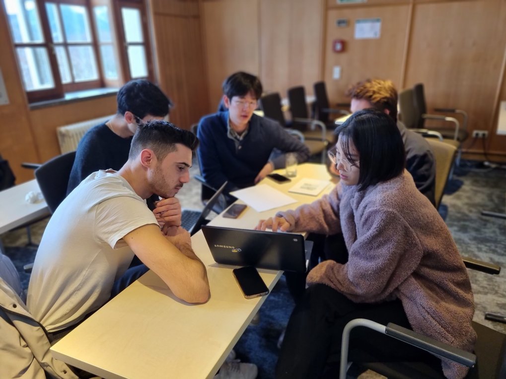 A group of students brainstorm on a laptop during an afternoon session on toy projects