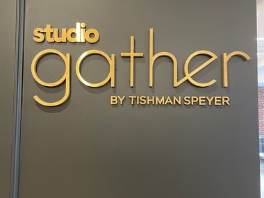 A sign "Studio Gather by Tishman Speyer" located in Rockefeller Plaza