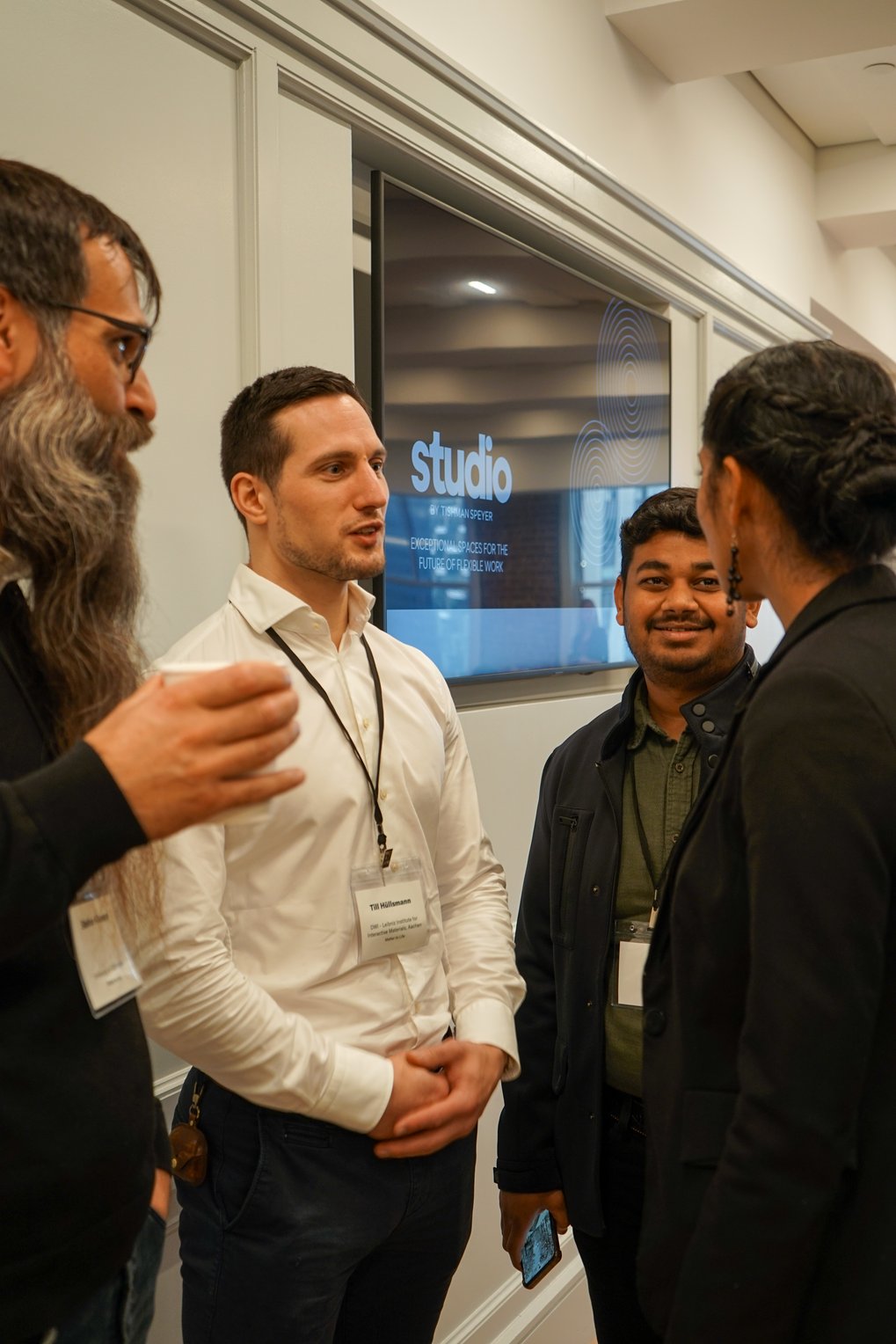 Four persons standing together and chatting