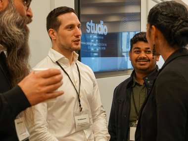 Four persons standing together and chatting