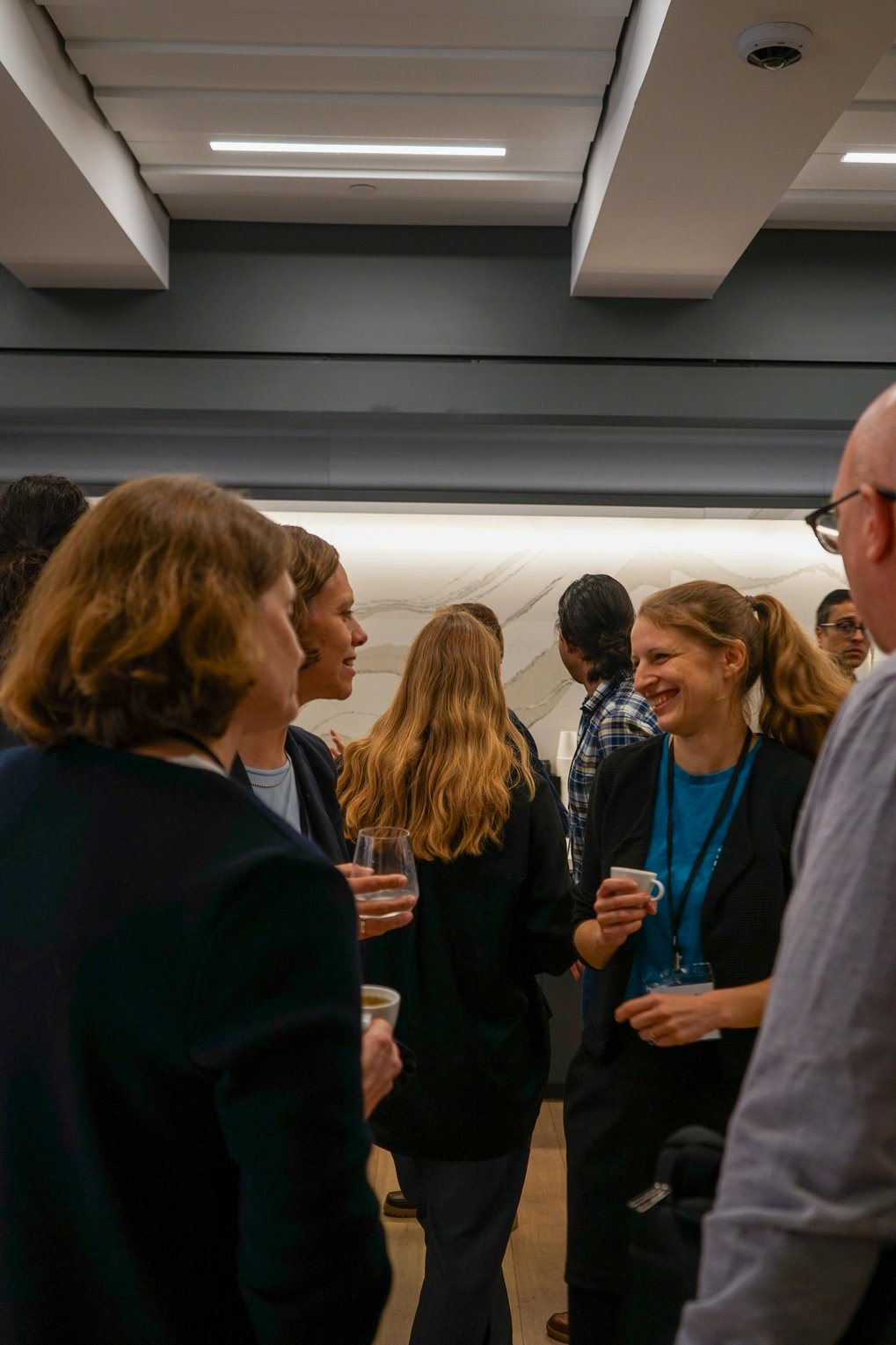 Lively discussion between a group of people. One of the women laughs.