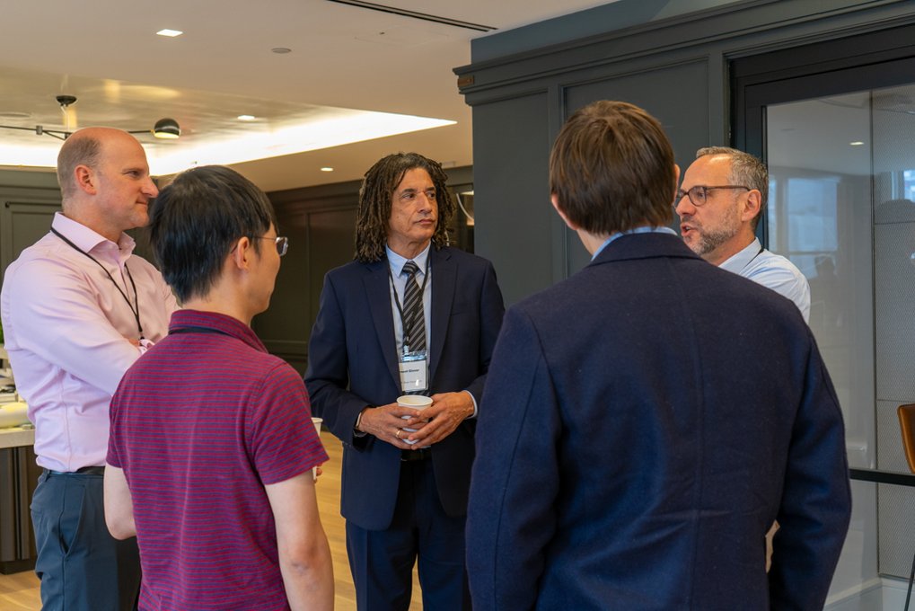 A group of Matter to Life conference participants gathered in a room, chatting and exchanging ideas.