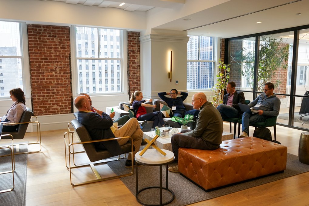 Some people are sitting comfortably around a lounge table chatting.