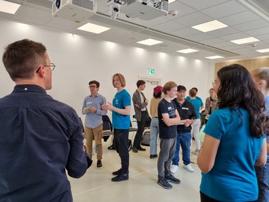 Group of participants in a well-lit classroom engaging in conversations and networking during an interactive session.