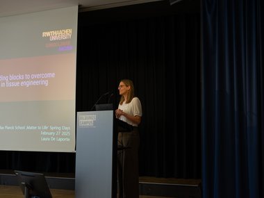 A conference presentation addresses overcoming challenges in tissue engineering, featuring speaker Laura De Laporte at the Max Planck School event.