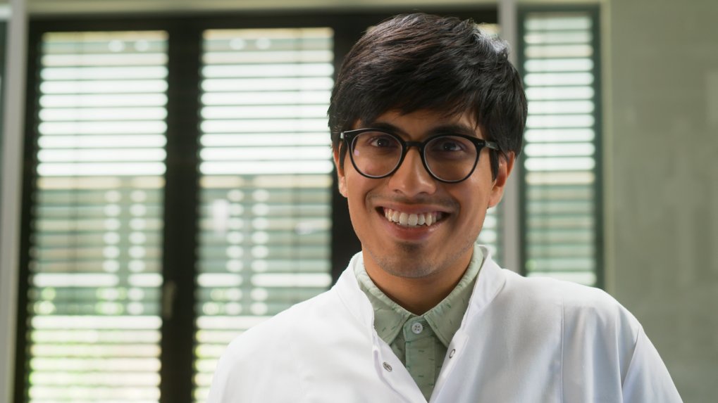 Matter to Life student wearing a lab coat smiling at the camera – portrait in a research setting