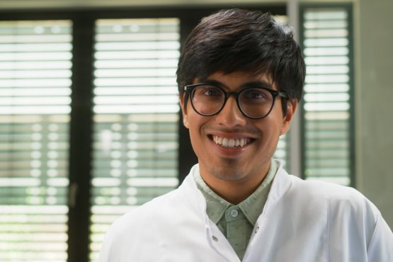 Matter to Life student wearing a lab coat smiling at the camera – portrait in a research setting