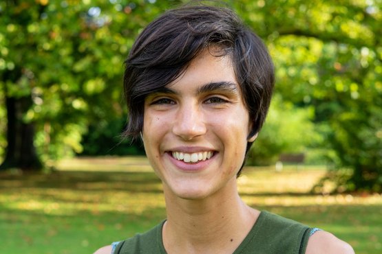 Portrait of Matter to Life PhD candidate Irene Pellini, with a sunlit meadow and trees in the background