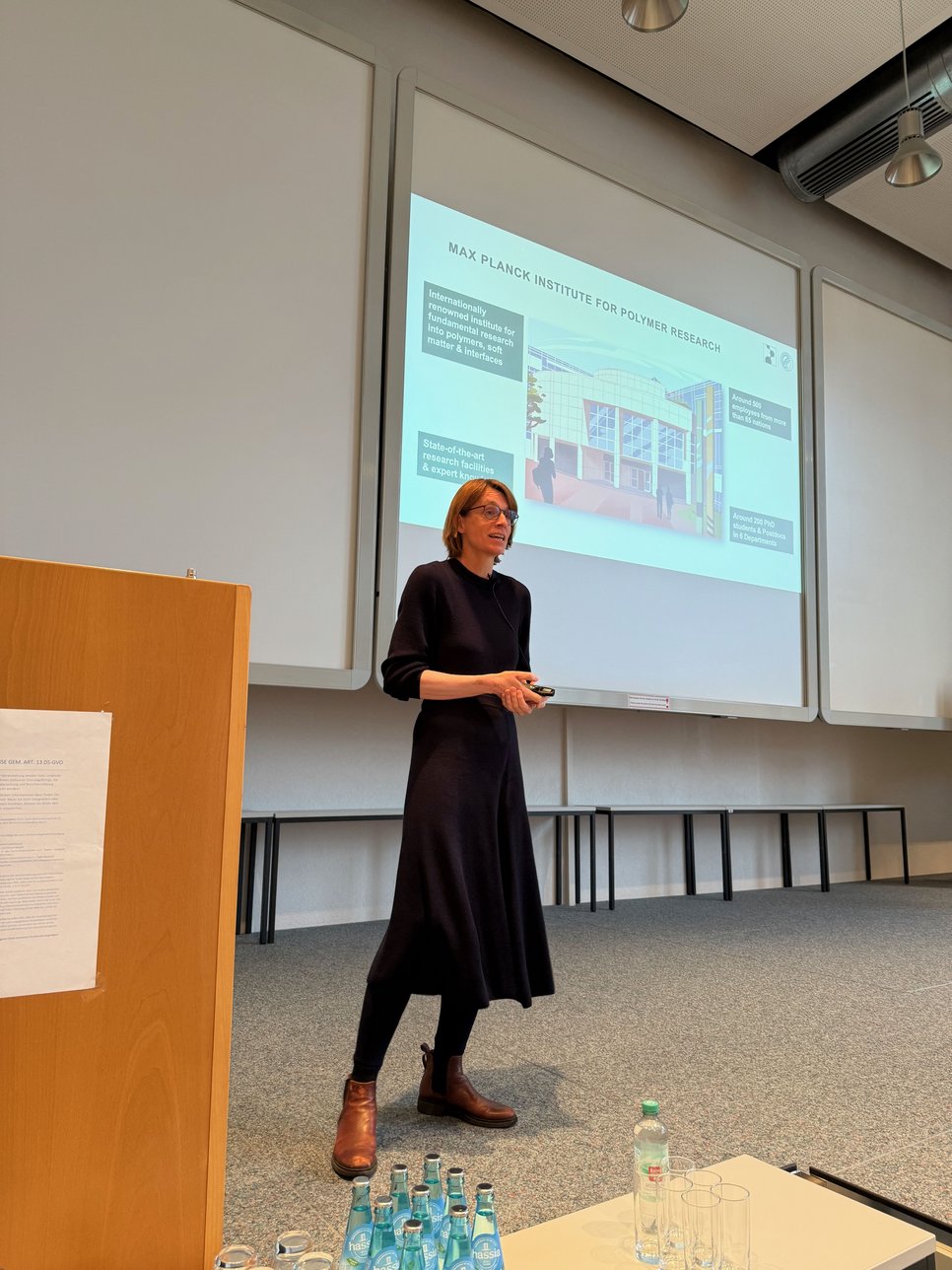 Presentation in a conference room with water bottles and glasses in the foreground.