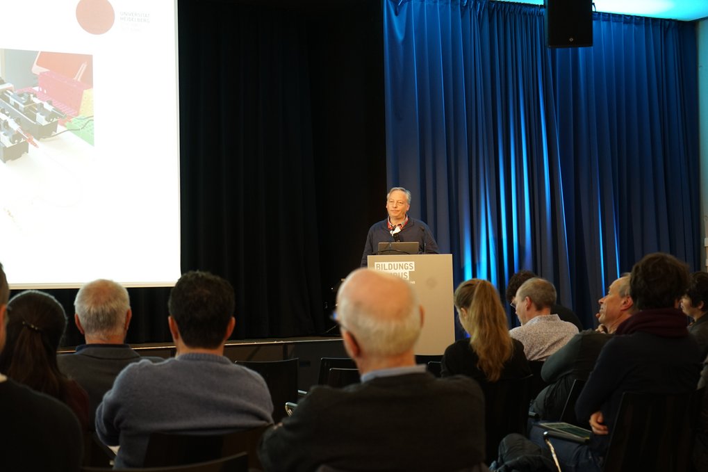 A speaker at a podium marked "Bildungskongress" addresses seated attendees