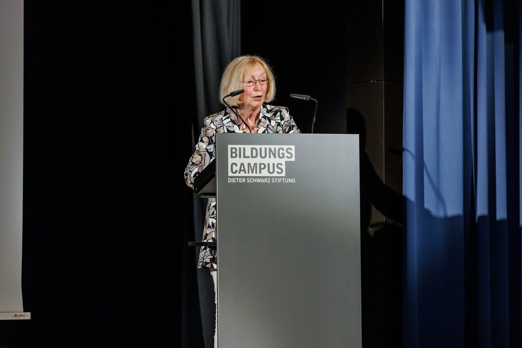 Johanna Wanka stands at a podium delivering the keynote speech at the Max Planck Schools graduation ceremony