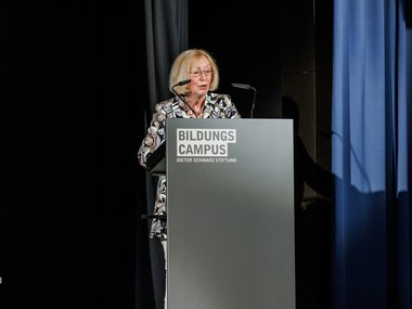 Johanna Wanka stands at a podium delivering the keynote speech at the Max Planck Schools graduation ceremony
