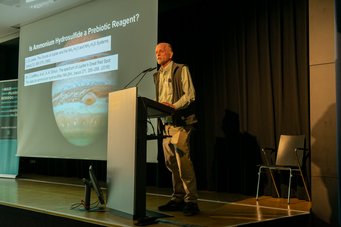 Nicholas Hud on the origins side of the field: early Earth as chemist rather than obstacle Nicholas Hud giving a lecture with a Jupiter image on the screen.